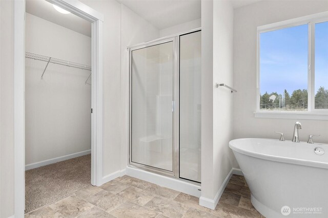 14756 88th Way SE Unit 10, Yelm, WA 98597 - full bathroom featuring a stall shower, a spacious closet, a soaking tub, and stone finish flooring
