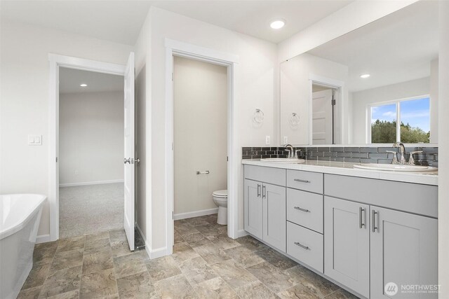 14756 88th Way SE Unit 10, Yelm, WA 98597 - full bath featuring double vanity, a soaking tub, stone finish floors, recessed lighting, and decorative backsplash