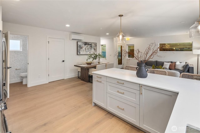 2616 E Roy St, Seattle, WA 98112 - kitchen with a wall mounted AC, light wood-style floors, light countertops, pendant lighting, and open floor plan