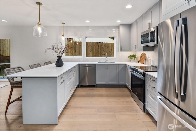 2616 E Roy St, Seattle, WA 98112 - kitchen with appliances with stainless steel finishes, gray cabinetry, a kitchen breakfast bar, light wood-style flooring, and recessed lighting