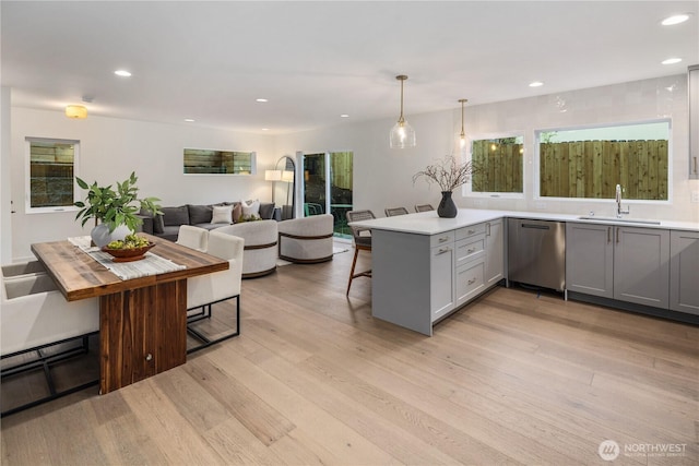 2616 E Roy St, Seattle, WA 98112 - kitchen featuring stainless steel dishwasher, gray cabinets, a kitchen bar, a peninsula, and light wood-style floors