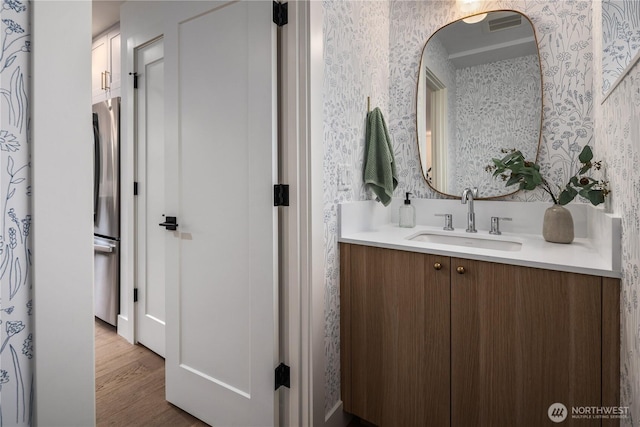 2616 E Roy St, Seattle, WA 98112 - bathroom featuring wallpapered walls, vanity, and wood finished floors
