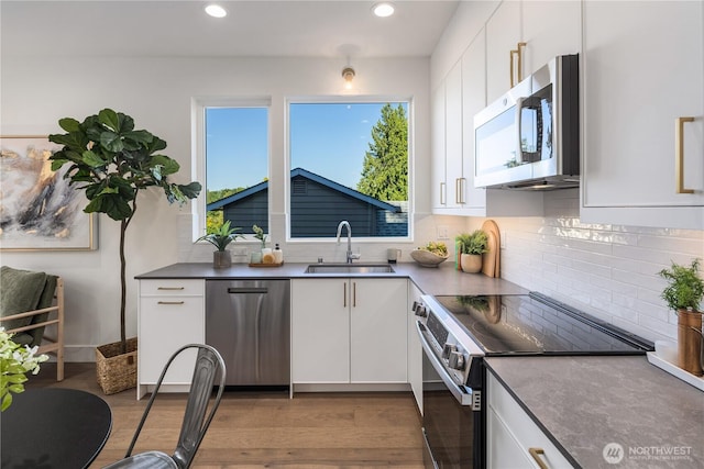 2618A E Roy St, Seattle, WA 98112 - kitchen featuring appliances with stainless steel finishes, white cabinetry, recessed lighting, and wood finished floors