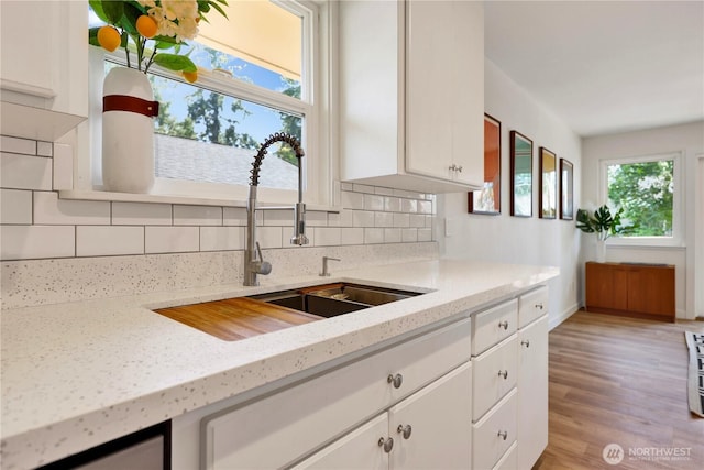 10507 NE 193rd St, Bothell, WA 98011 - kitchen featuring tasteful backsplash, white cabinetry, light wood finished floors, and light stone countertops