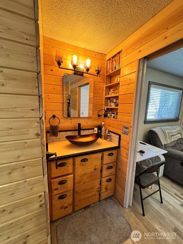 8839 Daffodil Ln SE, Olympia, WA 98513 - bathroom featuring wooden walls, a textured ceiling, vanity, and wood finished floors