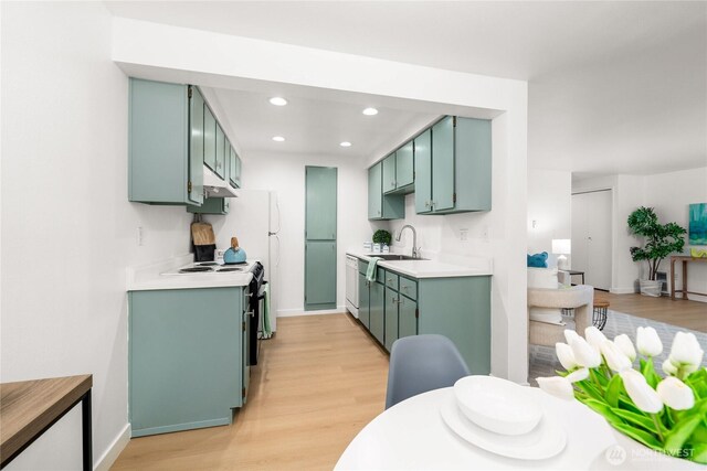 12504 NE 142nd Ln Unit C102, Kirkland, WA 98034 - kitchen with light countertops, green cabinets, under cabinet range hood, light wood-type flooring, and recessed lighting