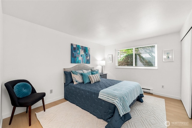 12504 NE 142nd Ln Unit C102, Kirkland, WA 98034 - bedroom featuring a baseboard radiator and light wood-style flooring