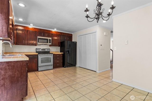 2621 Mountain View Ave W Unit 5B, Tacoma, WA 98466 - kitchen featuring appliances with stainless steel finishes, tile counters, light tile patterned flooring, ornamental molding, and a chandelier