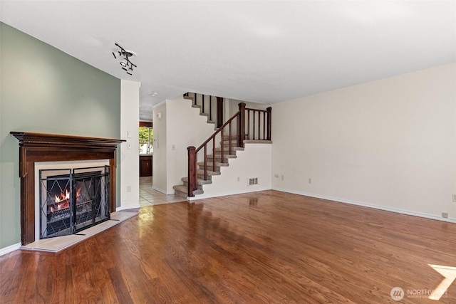 2621 Mountain View Ave W Unit 5B, Tacoma, WA 98466 - unfurnished living room with wood finished floors, stairs, and a lit fireplace