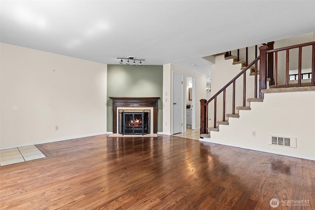 2621 Mountain View Ave W Unit 5B, Tacoma, WA 98466 - unfurnished living room featuring wood finished floors, stairs, a warm lit fireplace, and track lighting