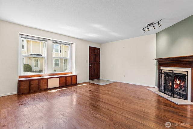 2621 Mountain View Ave W Unit 5B, Tacoma, WA 98466 - unfurnished living room with wood finished floors, a warm lit fireplace, and track lighting