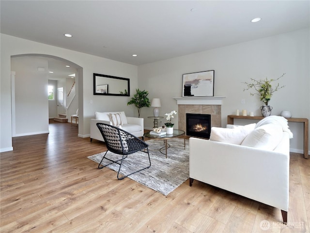 16271 SE 181st St, Renton, WA 98058 - living area with wood finished floors, a tiled fireplace, arched walkways, stairway, and recessed lighting