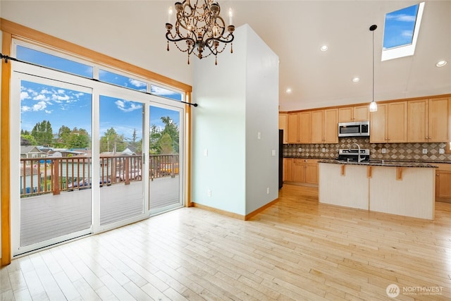 4824 Willow Dr, Blaine, WA 98230 - kitchen featuring stainless steel microwave, decorative backsplash, a kitchen bar, light brown cabinets, and recessed lighting