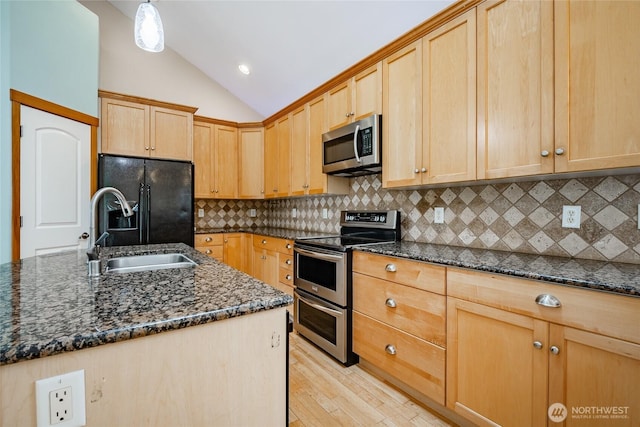 4824 Willow Dr, Blaine, WA 98230 - kitchen featuring stainless steel appliances, vaulted ceiling, light wood-type flooring, light brown cabinetry, and dark stone counters
