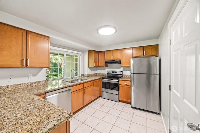 9822 NE 122nd St Unit U201, Kirkland, WA 98034 - kitchen with appliances with stainless steel finishes, under cabinet range hood, brown cabinets, light tile patterned floors, and light stone countertops