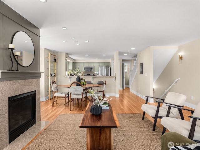 3011 Humes Pl W, Seattle, WA 98119 - living room with recessed lighting, light wood-type flooring, stairway, and a tiled fireplace