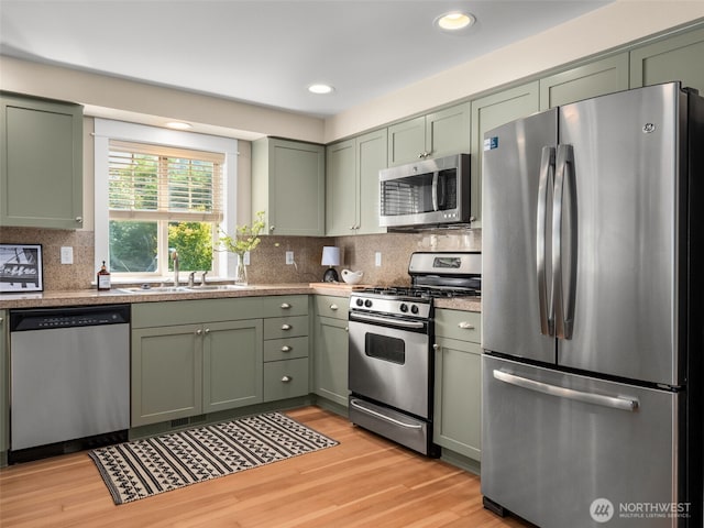 3011 Humes Pl W, Seattle, WA 98119 - kitchen featuring stainless steel appliances, green cabinetry, tasteful backsplash, and recessed lighting