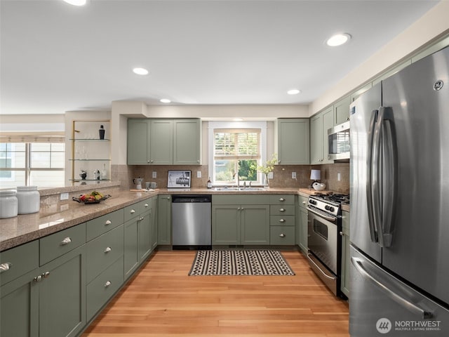 3011 Humes Pl W, Seattle, WA 98119 - kitchen featuring stainless steel appliances, green cabinetry, backsplash, light wood-style floors, and recessed lighting
