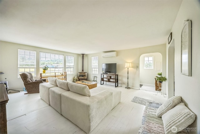 143 Mauerman Rd, Chehalis, WA 98532 - living room with a wood stove, an AC wall unit, and light wood-style floors
