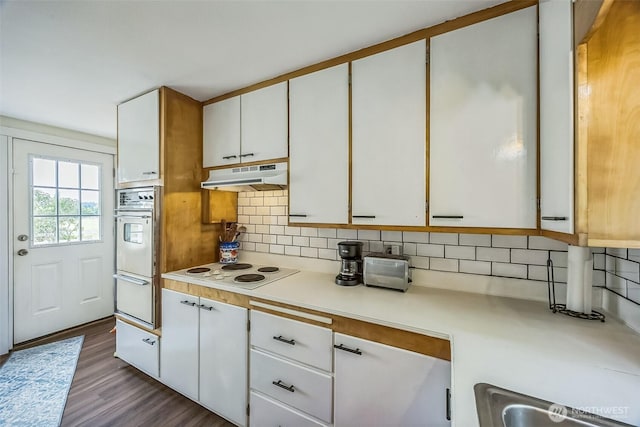 143 Mauerman Rd, Chehalis, WA 98532 - kitchen featuring under cabinet range hood, oven, light countertops, white cabinetry, and backsplash
