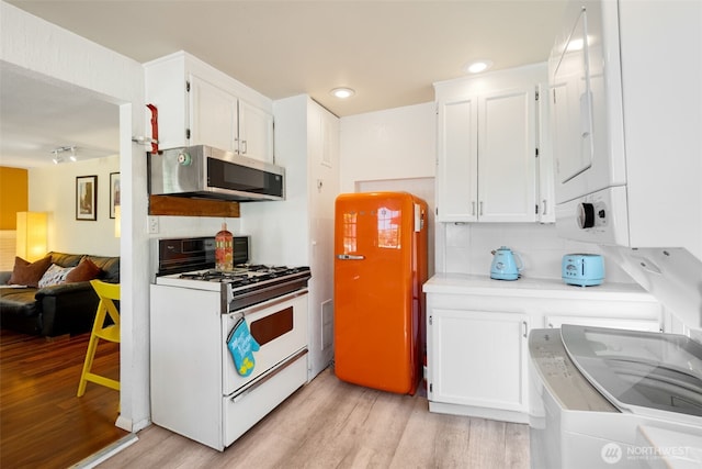 1524 30th Ave, Seattle, WA 98122 - kitchen with gas range gas stove, stainless steel microwave, light wood finished floors, and white cabinets