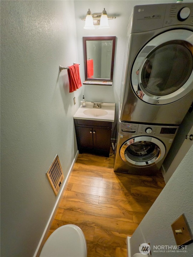 1717 150th Ave SE Unit 31, Bellevue, WA 98007 - laundry area with stacked washing machine and dryer and light wood finished floors