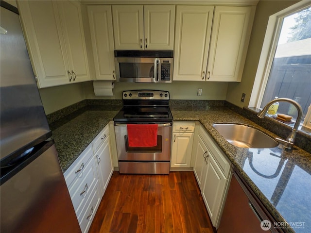 1717 150th Ave SE Unit 31, Bellevue, WA 98007 - kitchen with appliances with stainless steel finishes, dark wood finished floors, white cabinetry, and dark stone counters