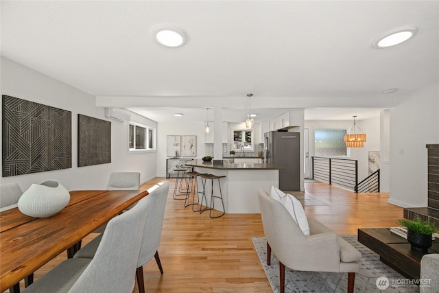 10032 35th Ave NE, Seattle, WA 98125 - dining space with light wood-style floors, a wall mounted air conditioner, and a chandelier