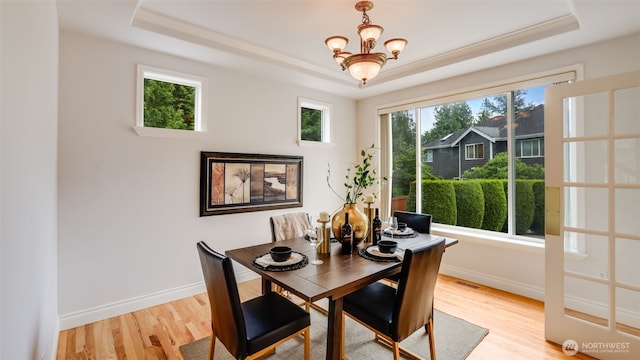 17303 SE 185th St, Renton, WA 98058 - dining area with a tray ceiling, light wood-type flooring, and a chandelier
