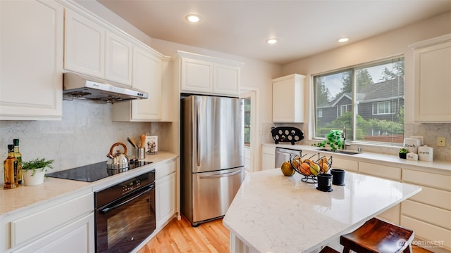 17303 SE 185th St, Renton, WA 98058 - kitchen with black appliances, under cabinet range hood, tasteful backsplash, recessed lighting, and white cabinets
