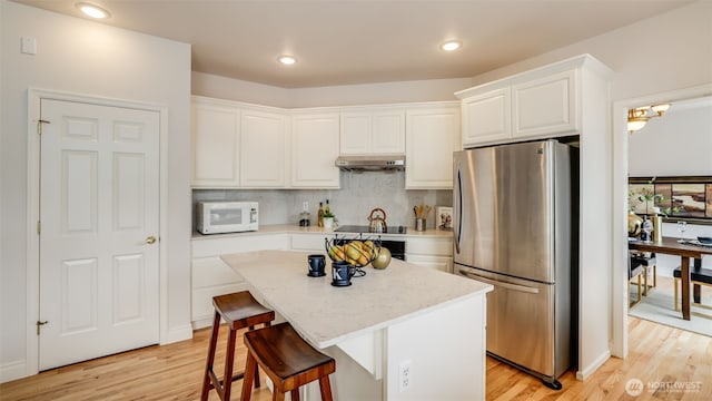 17303 SE 185th St, Renton, WA 98058 - kitchen featuring freestanding refrigerator, white microwave, under cabinet range hood, light wood finished floors, and recessed lighting