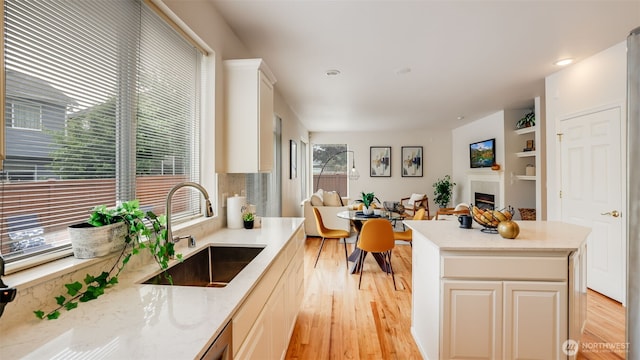 17303 SE 185th St, Renton, WA 98058 - kitchen with light wood-style floors, a fireplace, a center island, light stone counters, and open floor plan