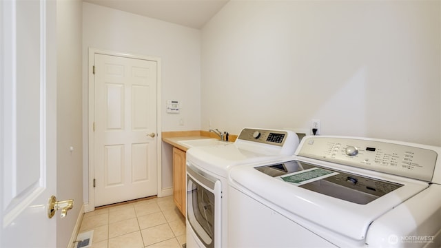 17303 SE 185th St, Renton, WA 98058 - laundry area with washer and clothes dryer, cabinet space, and light tile patterned flooring