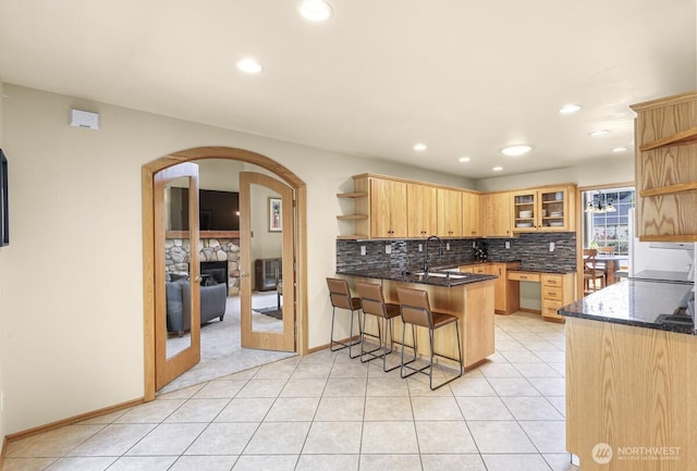 1307 Birchwood Dr, Everson, WA 98247 - kitchen with open shelves, a peninsula, arched walkways, decorative backsplash, and a kitchen breakfast bar