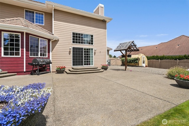 4618 51st Street Ct E, Tacoma, WA 98443 - rear view of property featuring a patio, a chimney, a fenced backyard, a storage shed, and entry steps