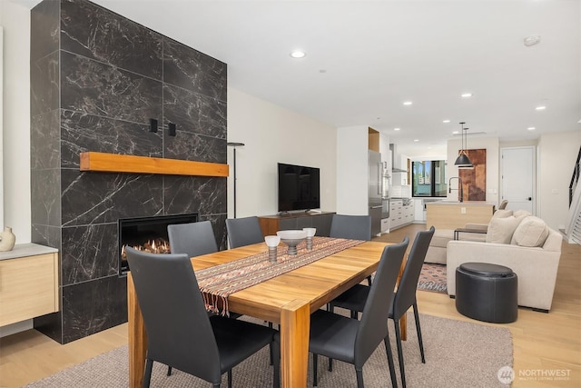 330 3rd Ave S Unit C, Kirkland, WA 98033 - dining room with light wood-style flooring, recessed lighting, a high end fireplace, an accent wall, and tile walls
