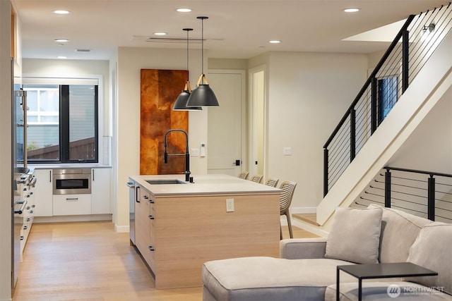 330 3rd Ave S Unit C, Kirkland, WA 98033 - kitchen with light wood-type flooring, recessed lighting, modern cabinets, pendant lighting, and a kitchen island with sink