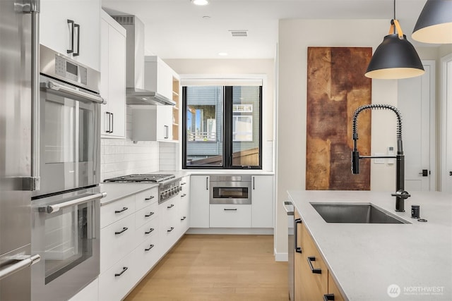 330 3rd Ave S Unit C, Kirkland, WA 98033 - kitchen featuring stainless steel appliances, wall chimney range hood, recessed lighting, light countertops, and decorative backsplash
