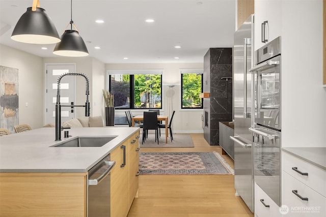 330 3rd Ave S Unit C, Kirkland, WA 98033 - kitchen with modern cabinets, stainless steel appliances, light wood finished floors, light countertops, and pendant lighting