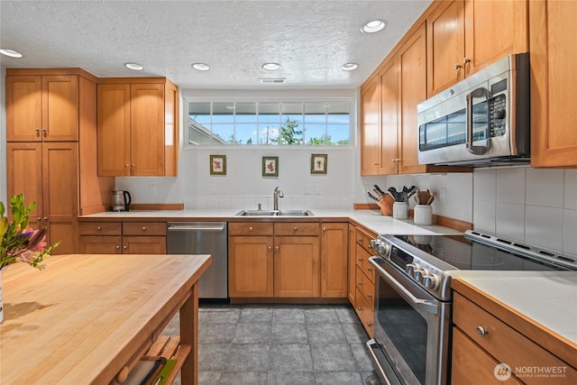541 75th Way NE, Olympia, WA 98506 - kitchen featuring stainless steel appliances, butcher block countertops, brown cabinets, recessed lighting, and a textured ceiling