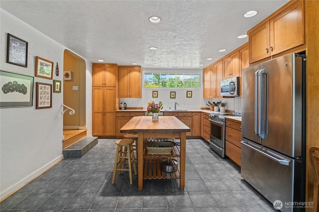 541 75th Way NE, Olympia, WA 98506 - kitchen with stainless steel appliances, recessed lighting, brown cabinets, and a textured ceiling