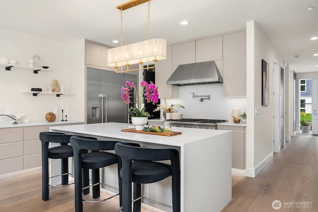 3968 162nd Pl SE, Bellevue, WA 98006 - kitchen featuring wall chimney range hood, light countertops, light wood finished floors, a kitchen island, and recessed lighting