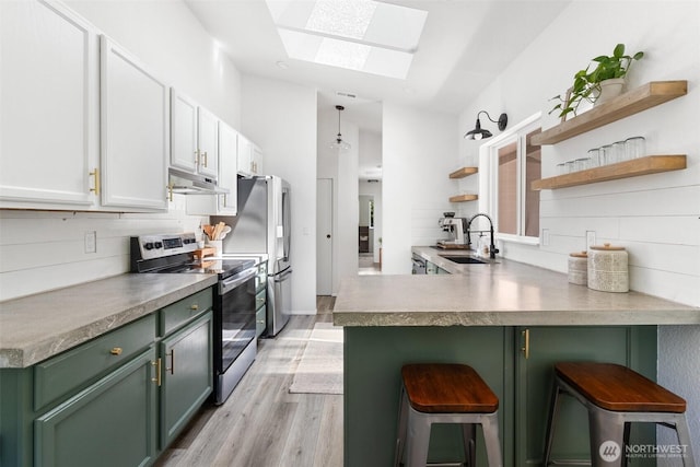 5414 70th Ave NE, Olympia, WA 98516 - kitchen with stainless steel electric stove, green cabinetry, a skylight, under cabinet range hood, and a peninsula