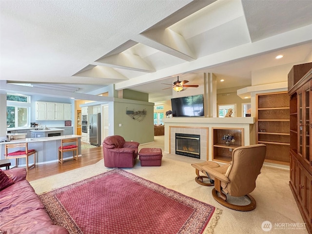 77 A Rd, Less Traveled, Sequim, WA 98382 - living room with a tile fireplace, a ceiling fan, recessed lighting, beamed ceiling, and light colored carpet