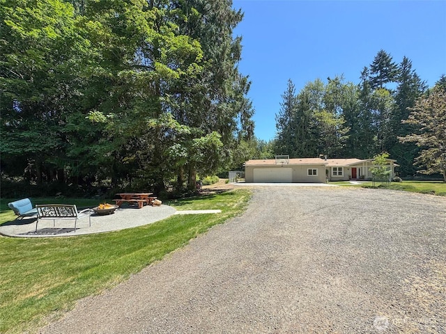 77 A Rd, Less Traveled, Sequim, WA 98382 - view of front of home with an outdoor fire pit, an attached garage, driveway, and a front lawn