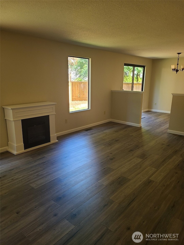 118 17th Ave SE, Olympia, WA 98501 - unfurnished living room featuring a chandelier, a fireplace, dark wood-style flooring, and a textured ceiling