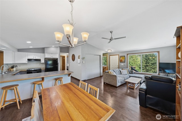 14068 Crater Lake Rd, Anacortes, WA 98221 - dining room featuring a ceiling fan, dark wood finished floors, a chandelier, lofted ceiling, and recessed lighting