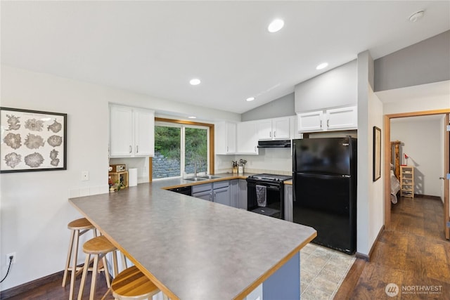 14068 Crater Lake Rd, Anacortes, WA 98221 - kitchen featuring black appliances, a peninsula, vaulted ceiling, white cabinetry, and under cabinet range hood