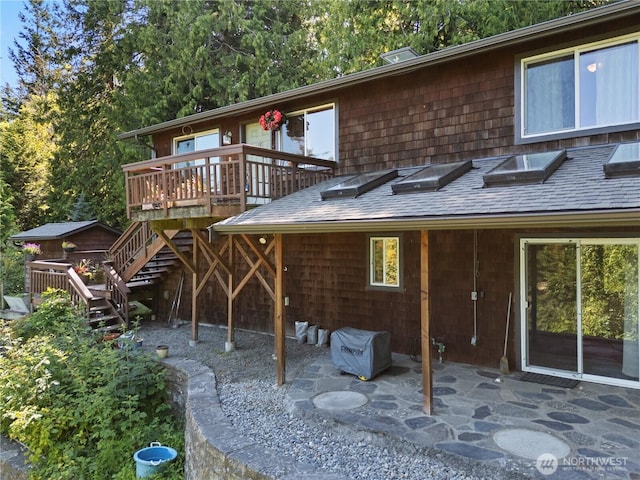 14068 Crater Lake Rd, Anacortes, WA 98221 - back of property with a shingled roof, stairway, a deck, and a patio