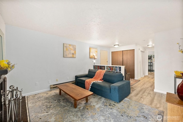 303 Kenyon St NW Unit 2D, Olympia, WA 98502 - living room with a baseboard radiator, light wood-style floors, and a textured ceiling